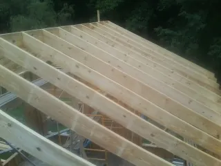 New roof rafters set over an addition before sheathing in Hartselle
