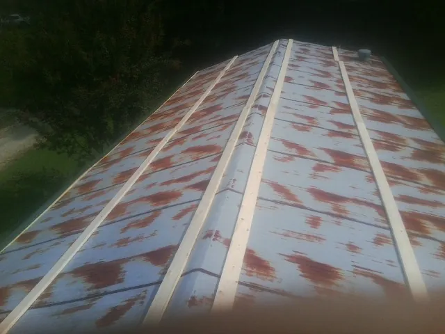 Rusted metal roof panels with new wood purlins before replacement — Storm Damage Roof Repair in Hartselle by Roofing Brothers