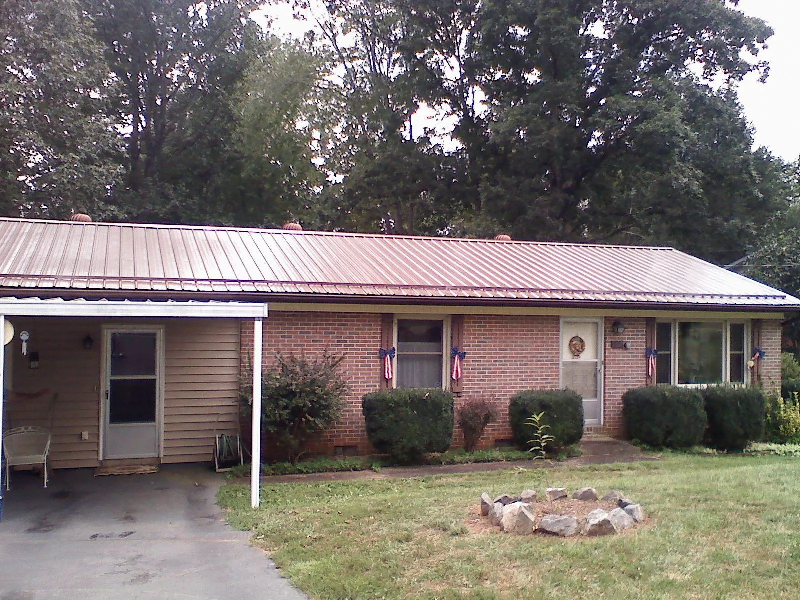 Bronze metal roof and carport on a brick ranch home — Roof Repair work by our crew in Hartselle
