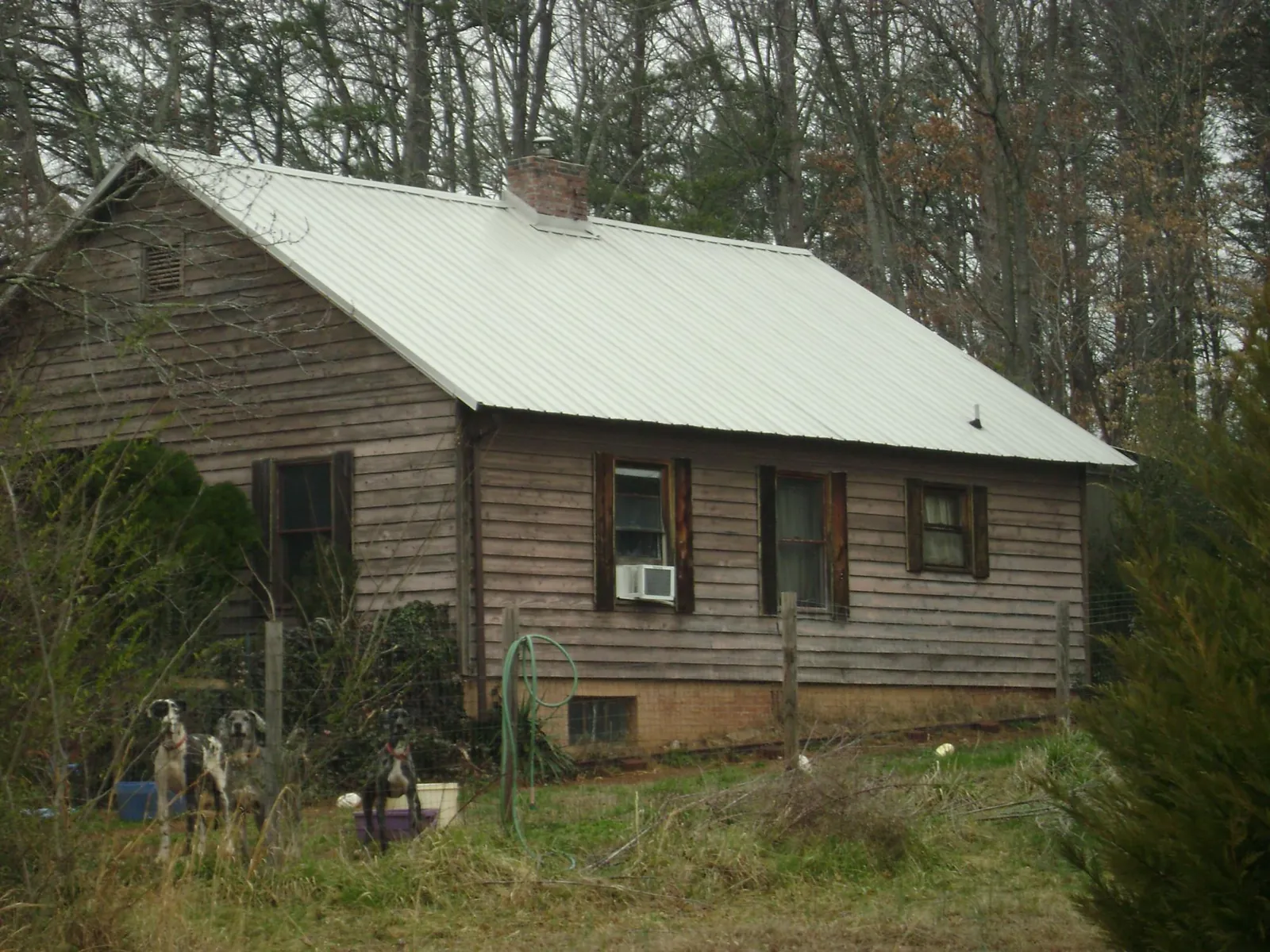 White metal roof on an old wood sided farmhouse, from a Asphalt Shingle Roof Repair job in Hartselle